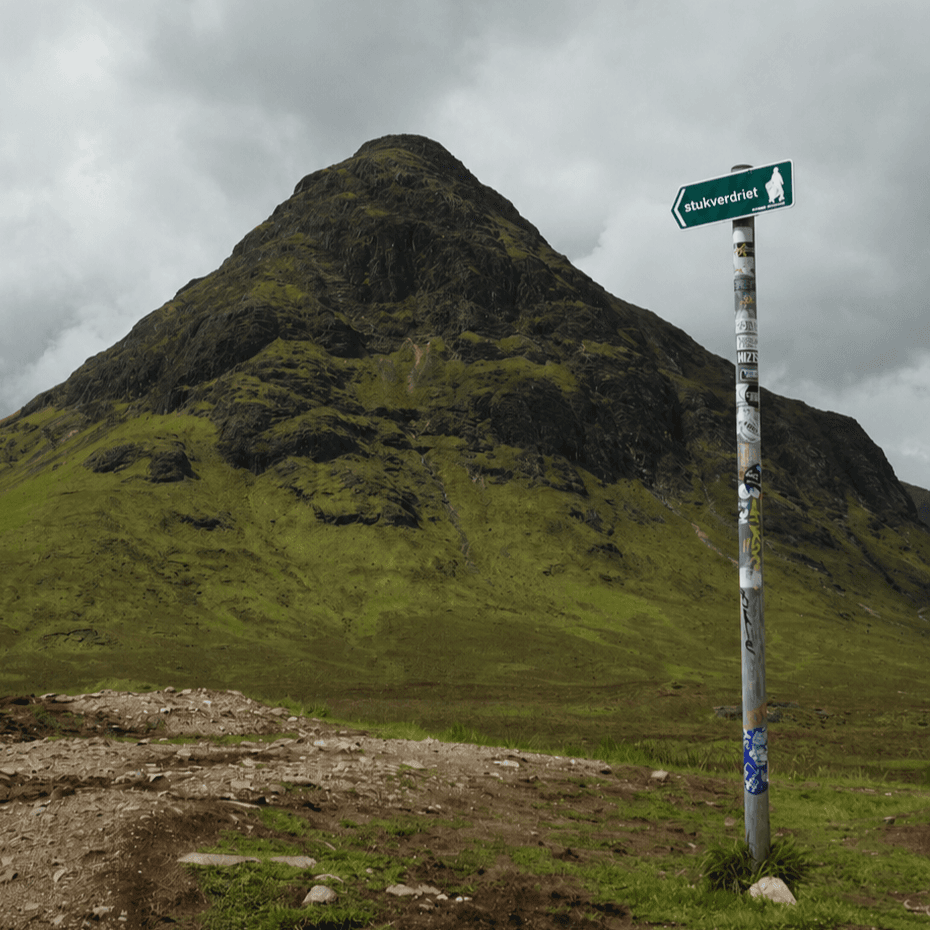 Wegwijzer met Stuk Verdriet op de pijl voor een berglandschap